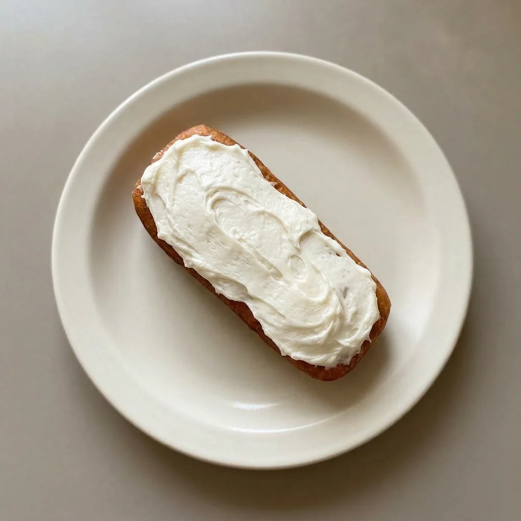 A serving of two stacked glazed donuts, icing dripping slightly over the top one.
