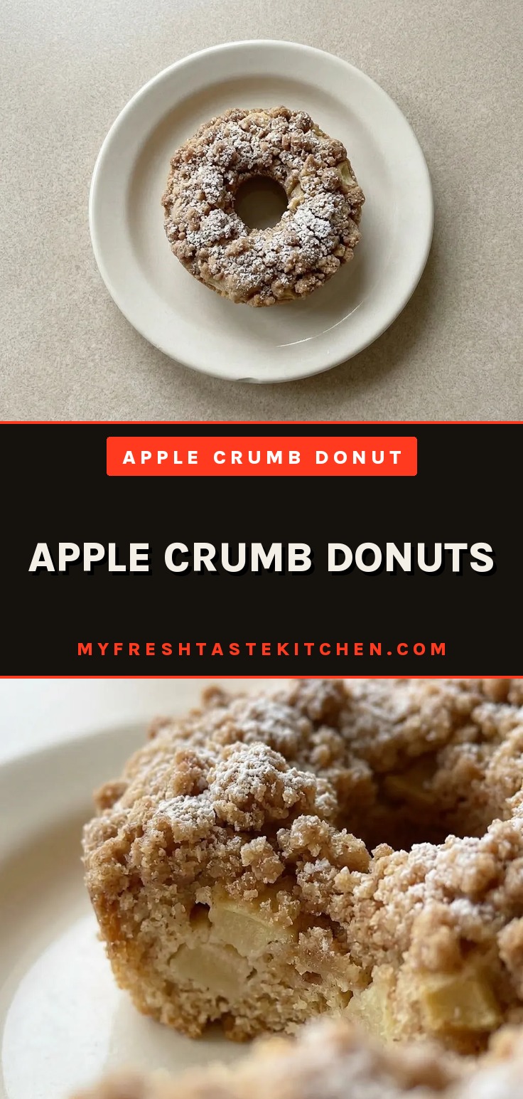 Apple crumb donuts on a cooling rack, topped with brown sugar crumble and dusted with powdered sugar, showing a tender crumb inside.