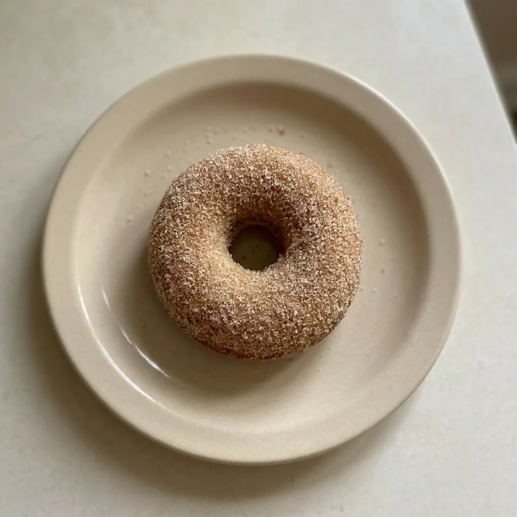 Ready to serve: three donuts dusted with cinnamon sugar, one slightly tilted.