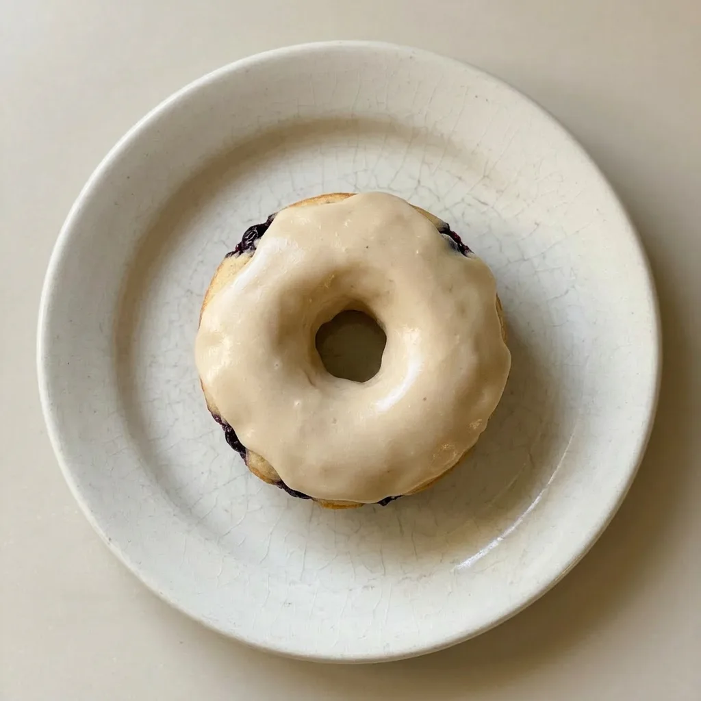 Ready to serve: two donuts with a glossy maple syrup topping and blueberries