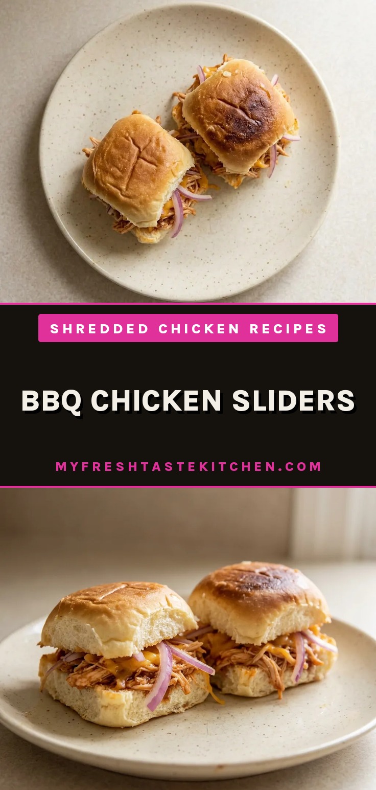 Looking down at three sliders on sweet rolls, topped with shredded chicken, BBQ sauce, melted cheddar, and red onion rings.