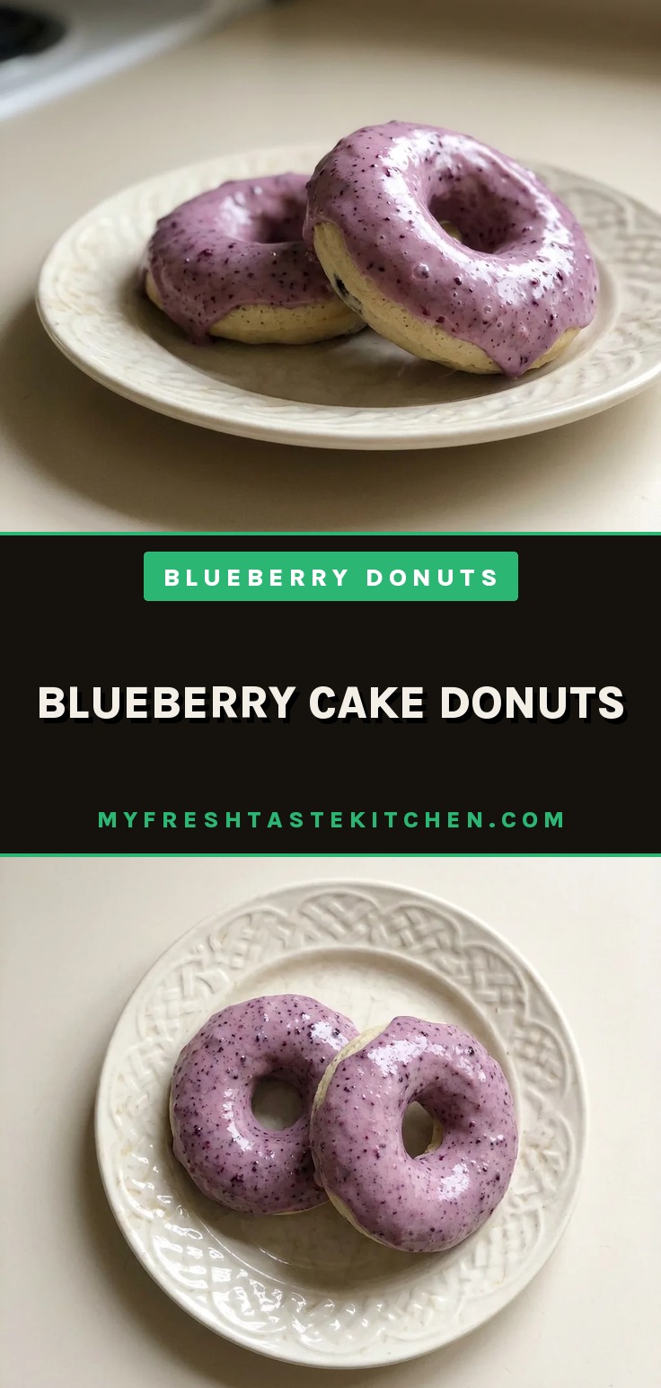 Blueberry cake donuts with blueberry glaze topping and visible bits of blueberries and butter in the crumb.