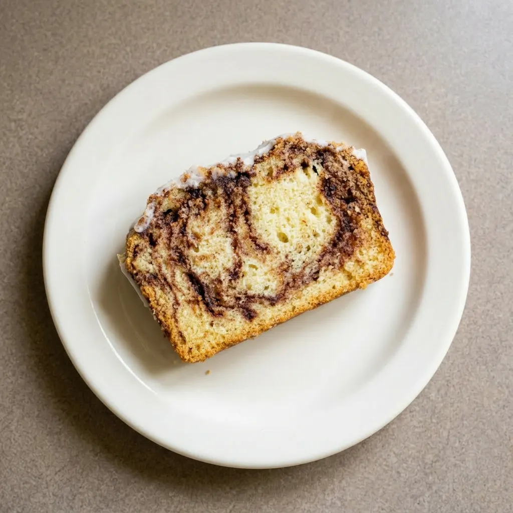 Plated slices of cinnamon swirl buttermilk bread, each with a cinnamon swirl pattern and a coating of vanilla glaze.