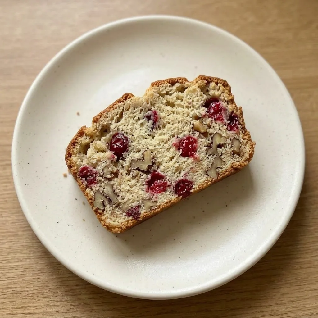 Ready to serve: a whole cranberry bread loaf with a golden crust and visible cranberries.