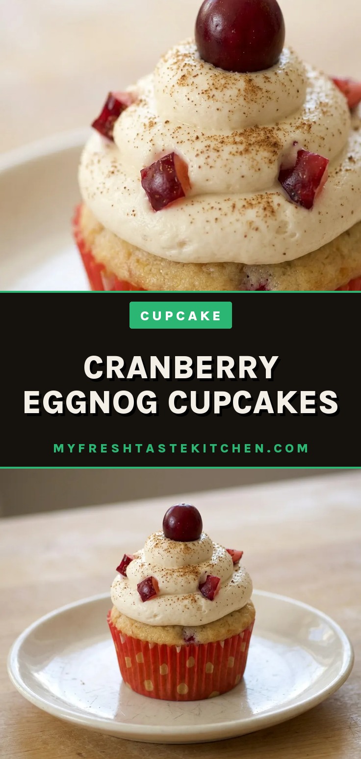 Bird's-eye view of a white chocolate-drizzled cupcake topped with a sugared cranberry and a cinnamon stick, with nutmeg specks visible.