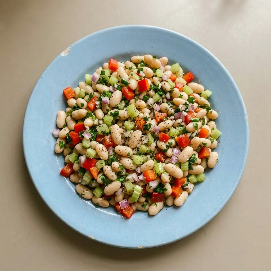 Ready to serve: white bean salad topped with red bell pepper, celery, red onion, and fresh parsley.