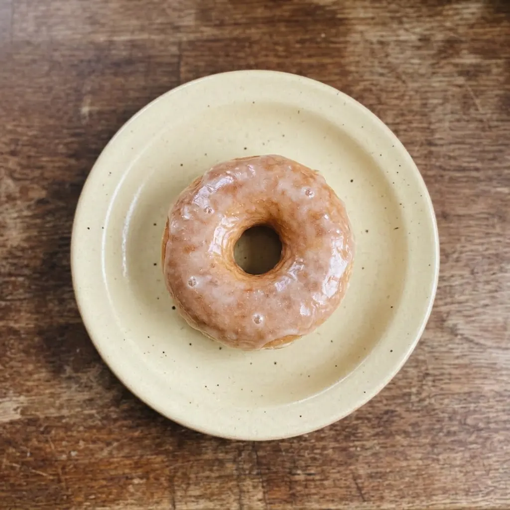 Ready to serve: a glazed sourdough donut with a glossy white icing coating.