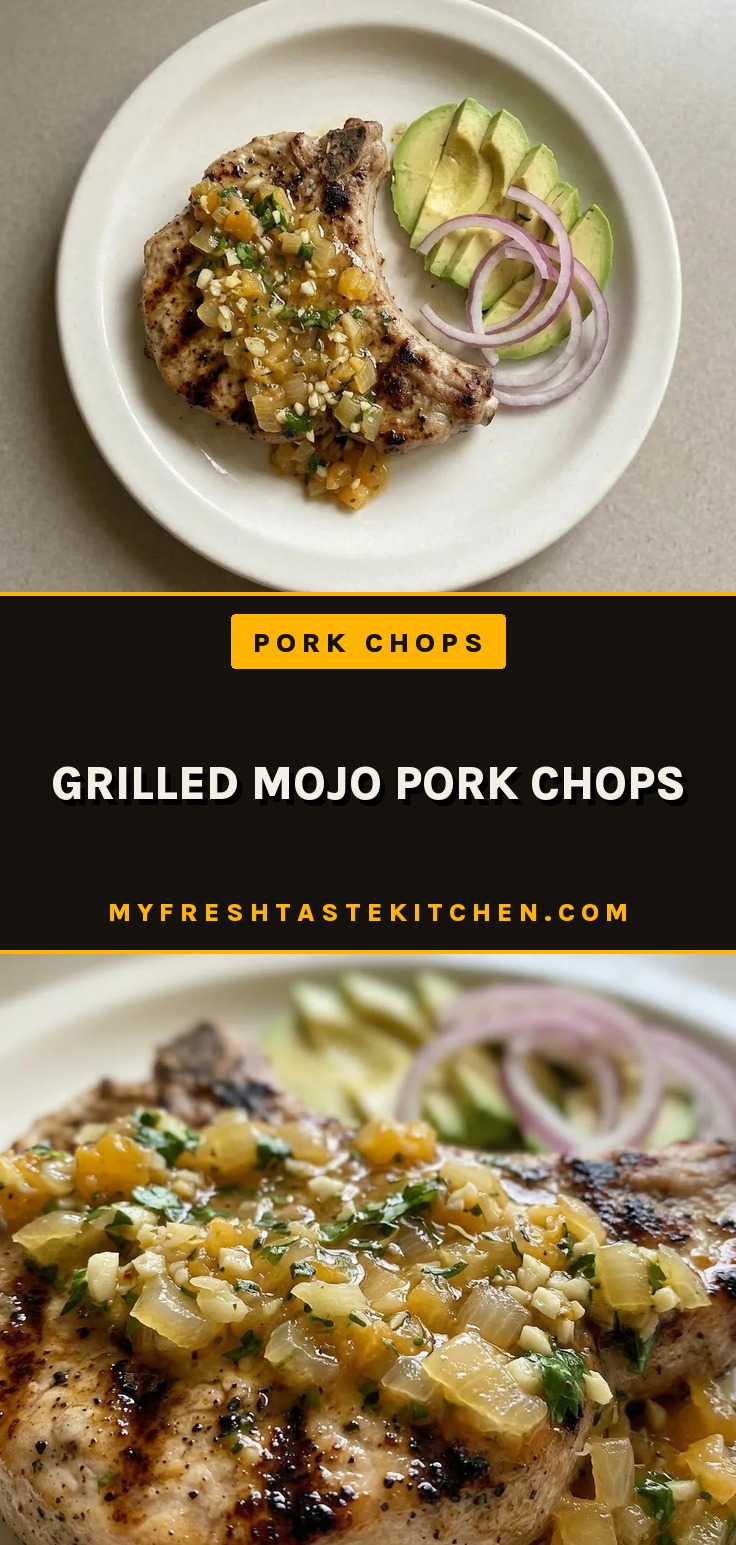 Top-down look at two grilled pork chops with bitter orange marinade, topped with garlic, oregano, cumin, and cilantro.