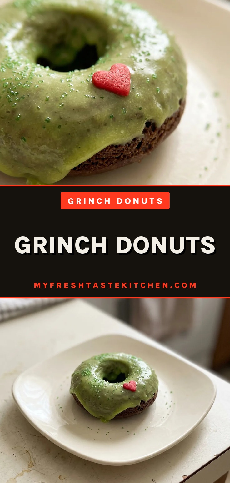 Grinch donuts with green frosted tops and red heart sprinkles, coated in green dusting sugar.