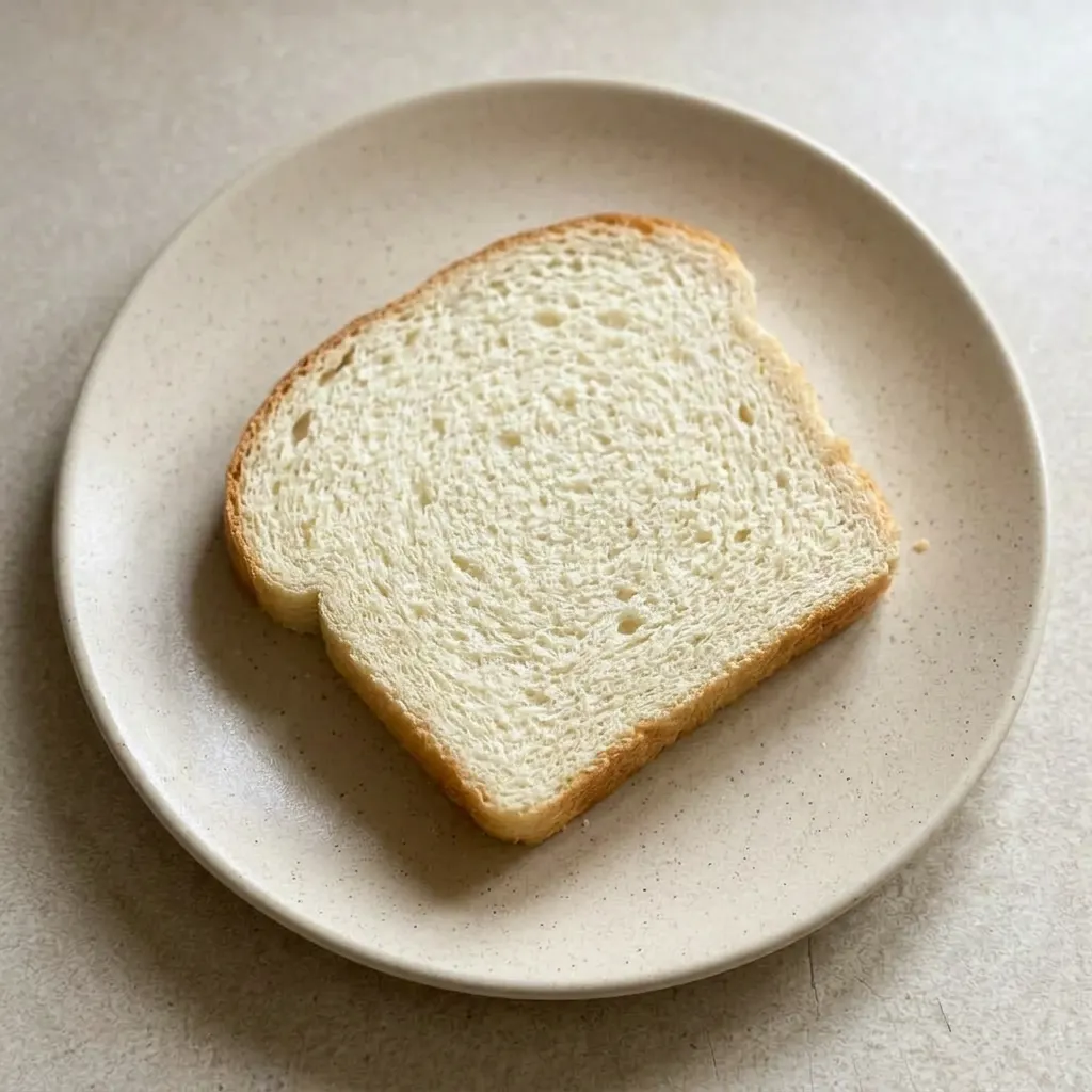 Ready to serve: a whole loaf on a wooden board, with a pat of butter on top and honey drizzled over one slice.