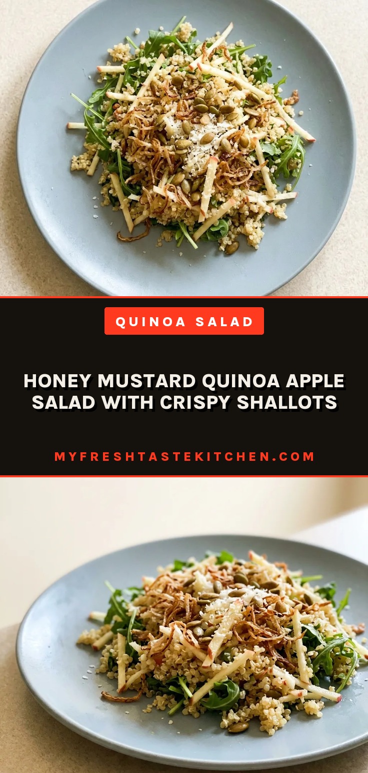 Looking down at a bed of arugula topped with quinoa, diced apple, and crispy shallots, drizzled with honey mustard vinaigrette.