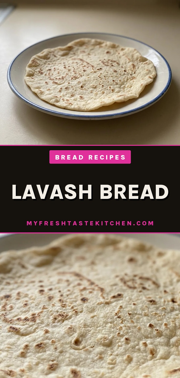 Overhead shot of a round lavash bread with a golden-brown crust and small air bubbles, topped with honey and a dusting of bread flour.