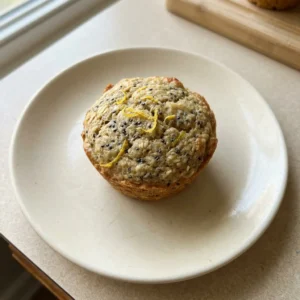 Top-down look at a lemon chia oat muffin with visible chia seeds and a glossy top.