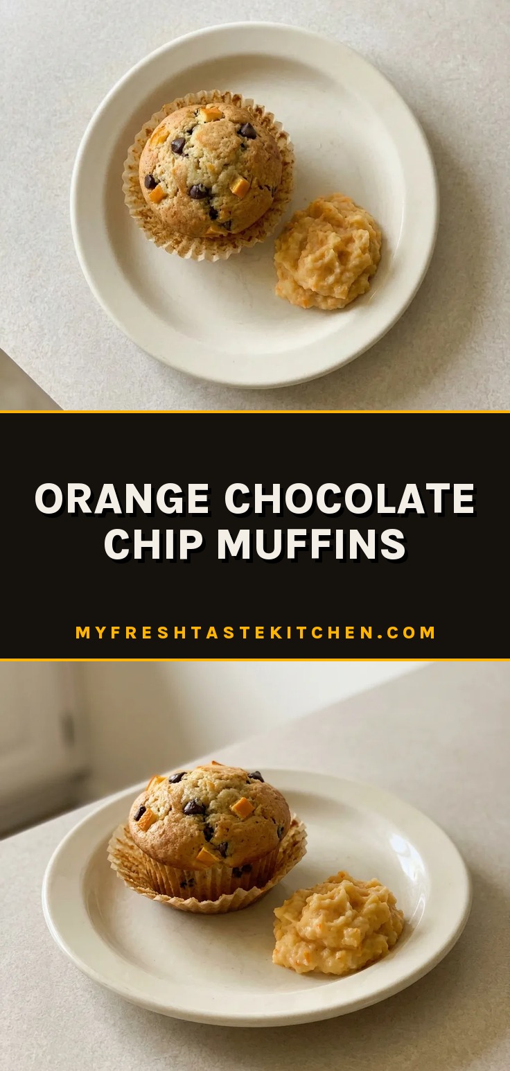 Looking down at a round orange muffin topped with chocolate chips and a slice of orange.