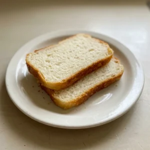 Looking down at a round loaf of sourdough bread with a golden-brown crust and a spiral scoring pattern.