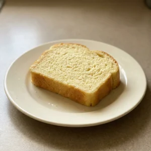 Top-down look at a round, golden-brown bread loaf with a cracked, buttery crust.