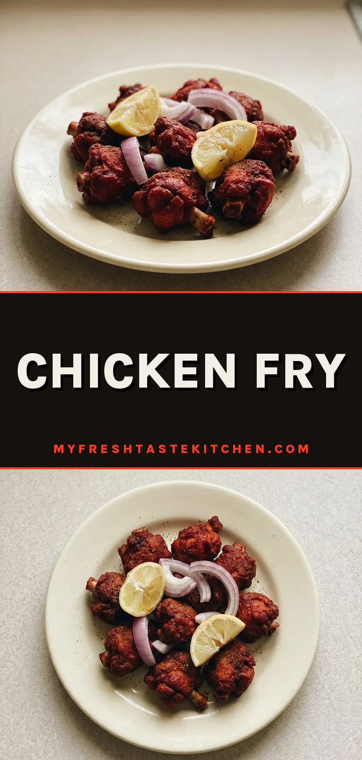 Looking down at crispy chicken pieces with green chili slices and curry leaves scattered on top.