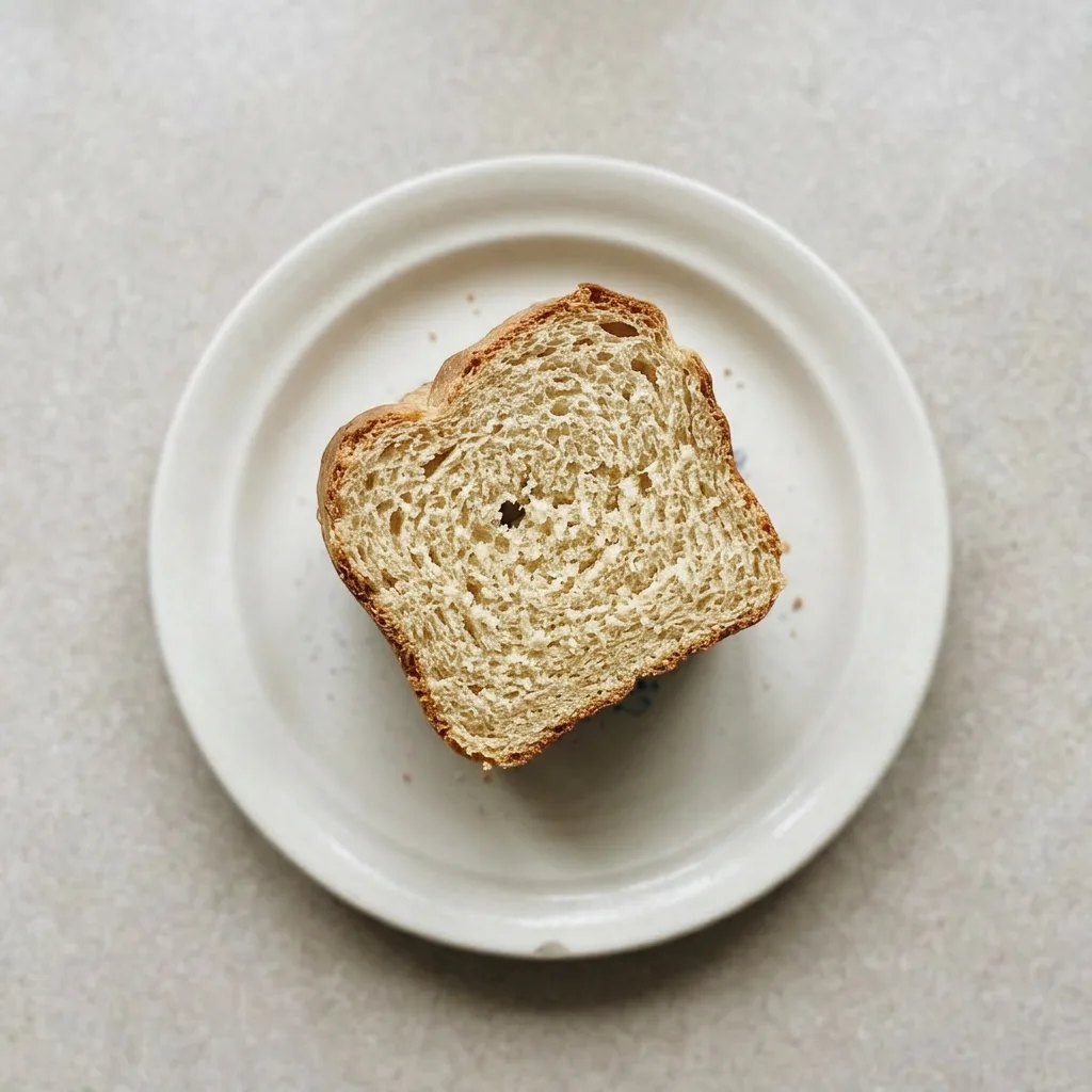 Ready to serve: a loaf of bread with a crisp crust, sliced and arranged on a wooden board.