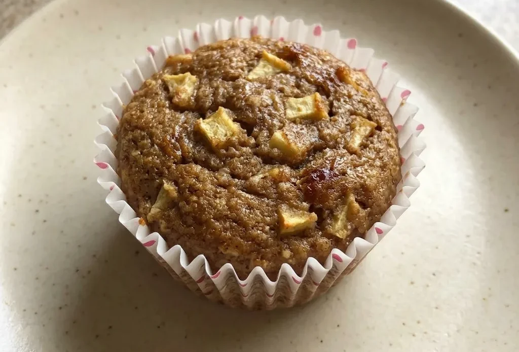 Looking down at three apple cinnamon muffins with almond flour tops and date paste swirls.