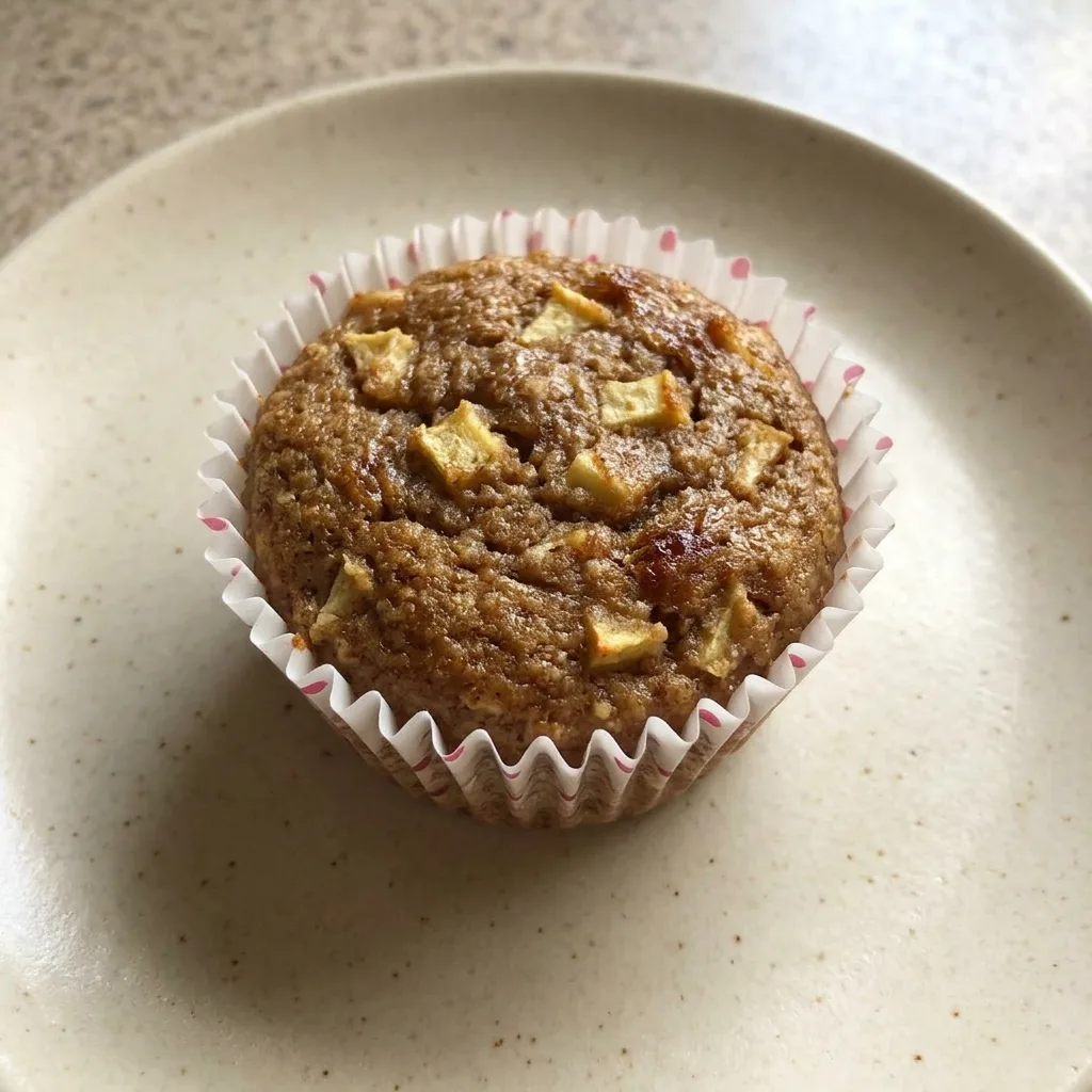 Looking down at three apple cinnamon muffins with almond flour tops and date paste swirls.