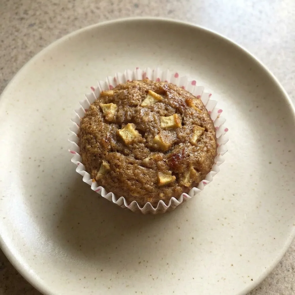 A plate of apple cinnamon muffins with visible almond flour and coconut oil sheen.