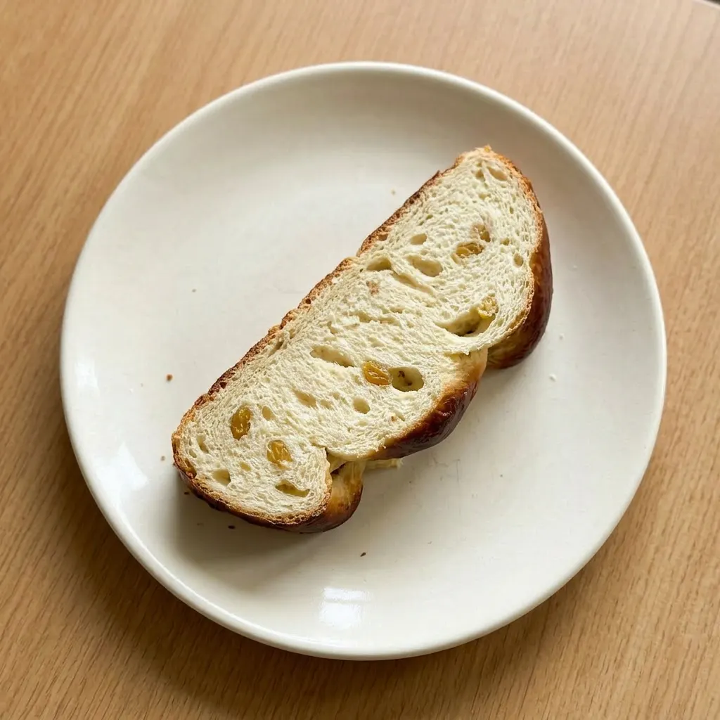 Ready to serve: a whole braided loaf with golden raisins dotting the golden-brown top.