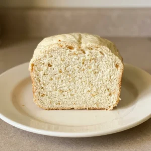 Bird's-eye view of a round loaf of garlic bread, sliced into wedges, with visible garlic pieces and olive oil sheen on the crust.