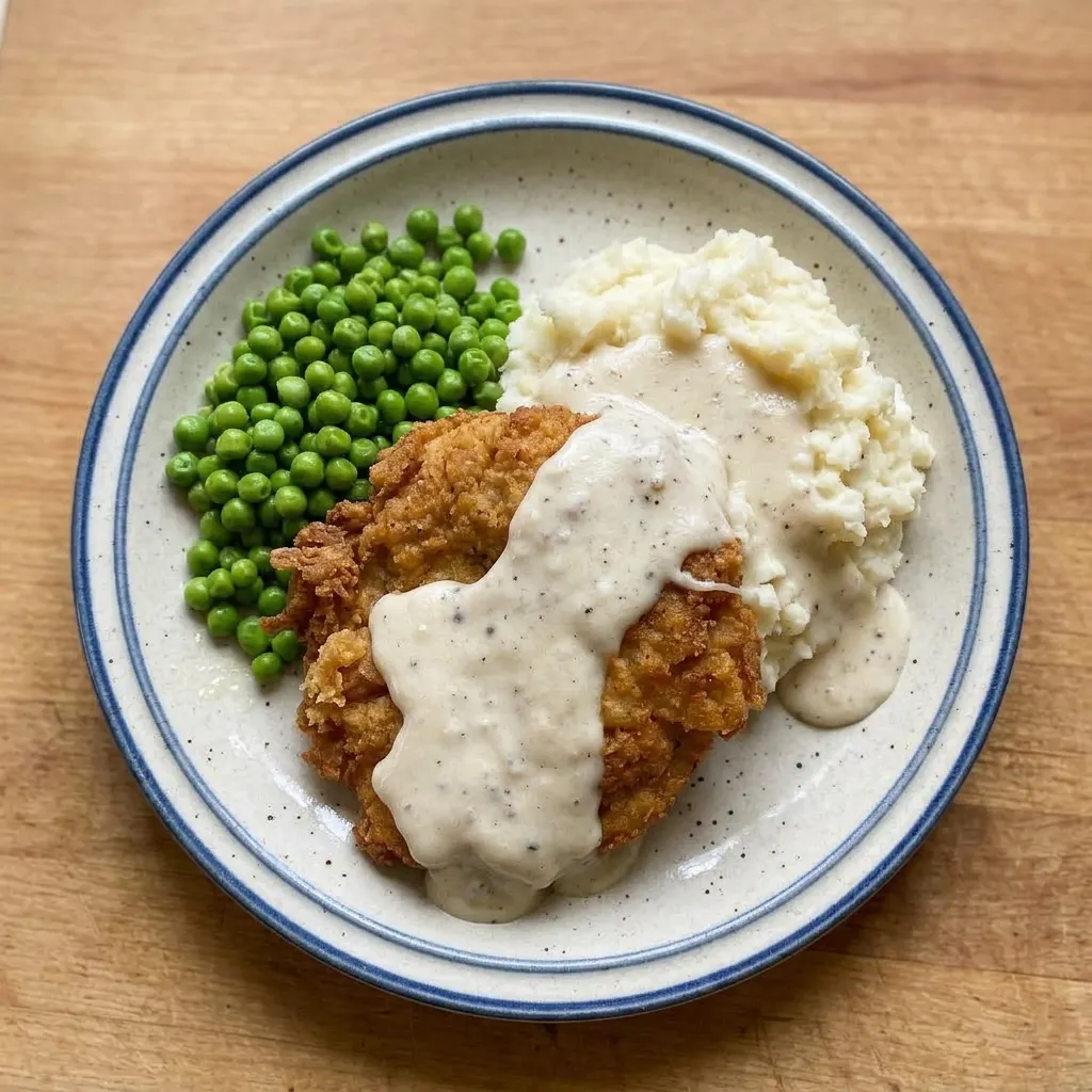 Plated country fried steak with creamy gravy, seasoned with black pepper and a hint of Worcestershire sauce.