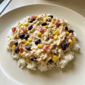 Top-down look at chicken with black beans, corn, diced tomatoes, and green chilies in creamy sauce.