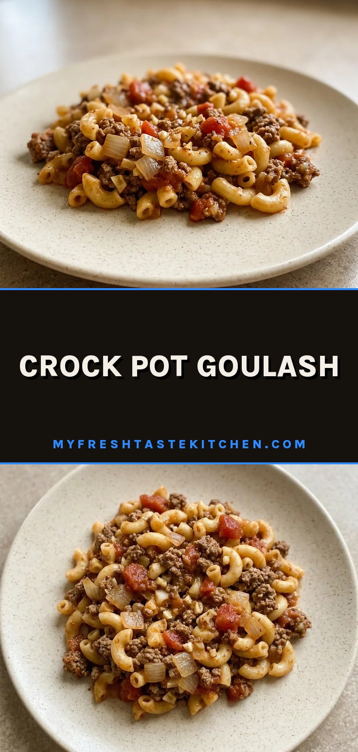 Looking down at a bowl of goulash with elbow macaroni, ground beef, and diced tomatoes in a thick red sauce, topped with paprika and Italian seasoning.