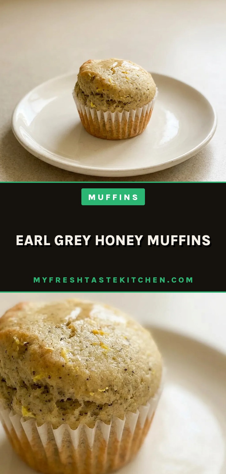 Overhead shot of a round muffin with a domed top, drizzled with honey and topped with a lemon slice and a few tea leaves.