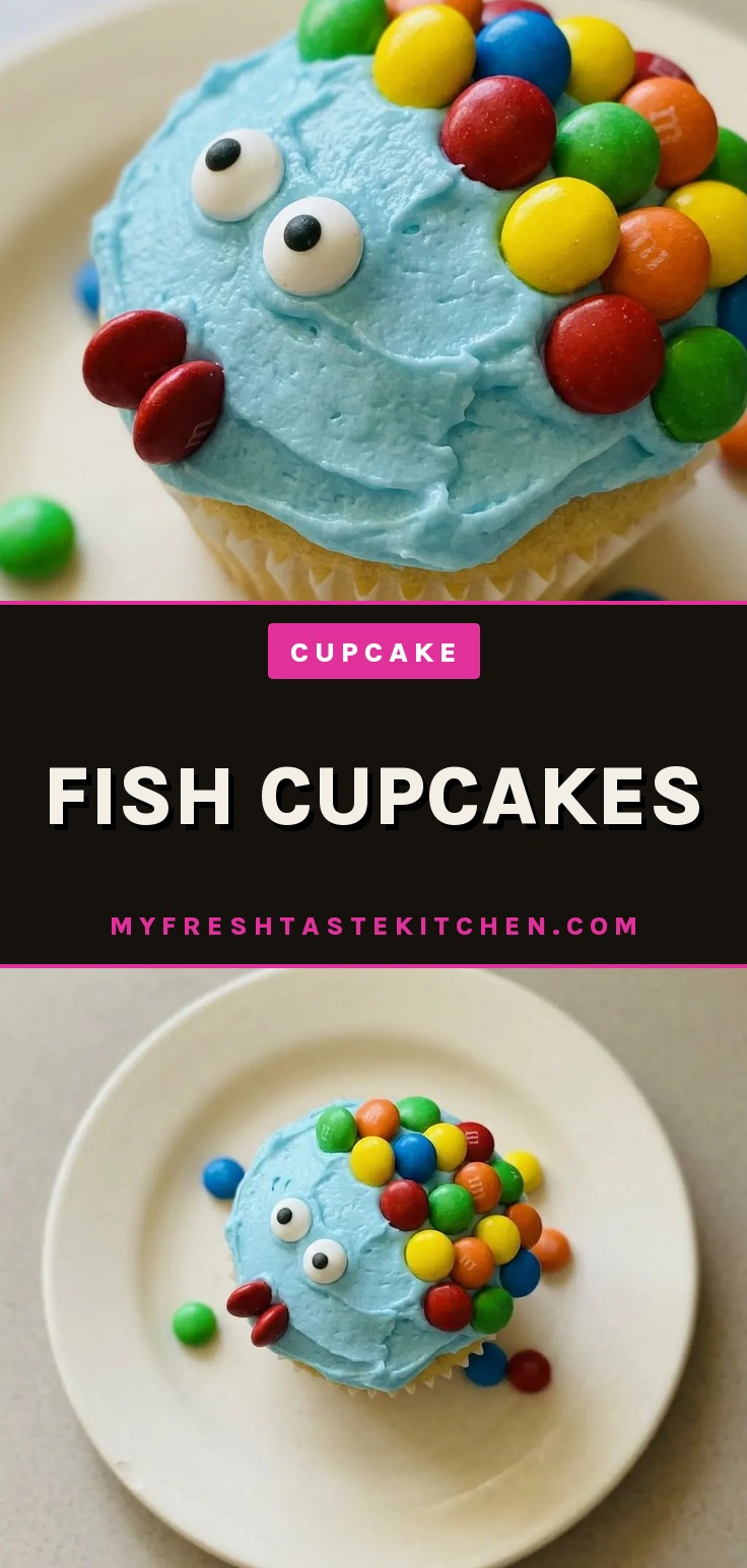 Bird's-eye view of a fish-shaped cupcake with blue frosting, candy scales, and candy eyes on a white background.