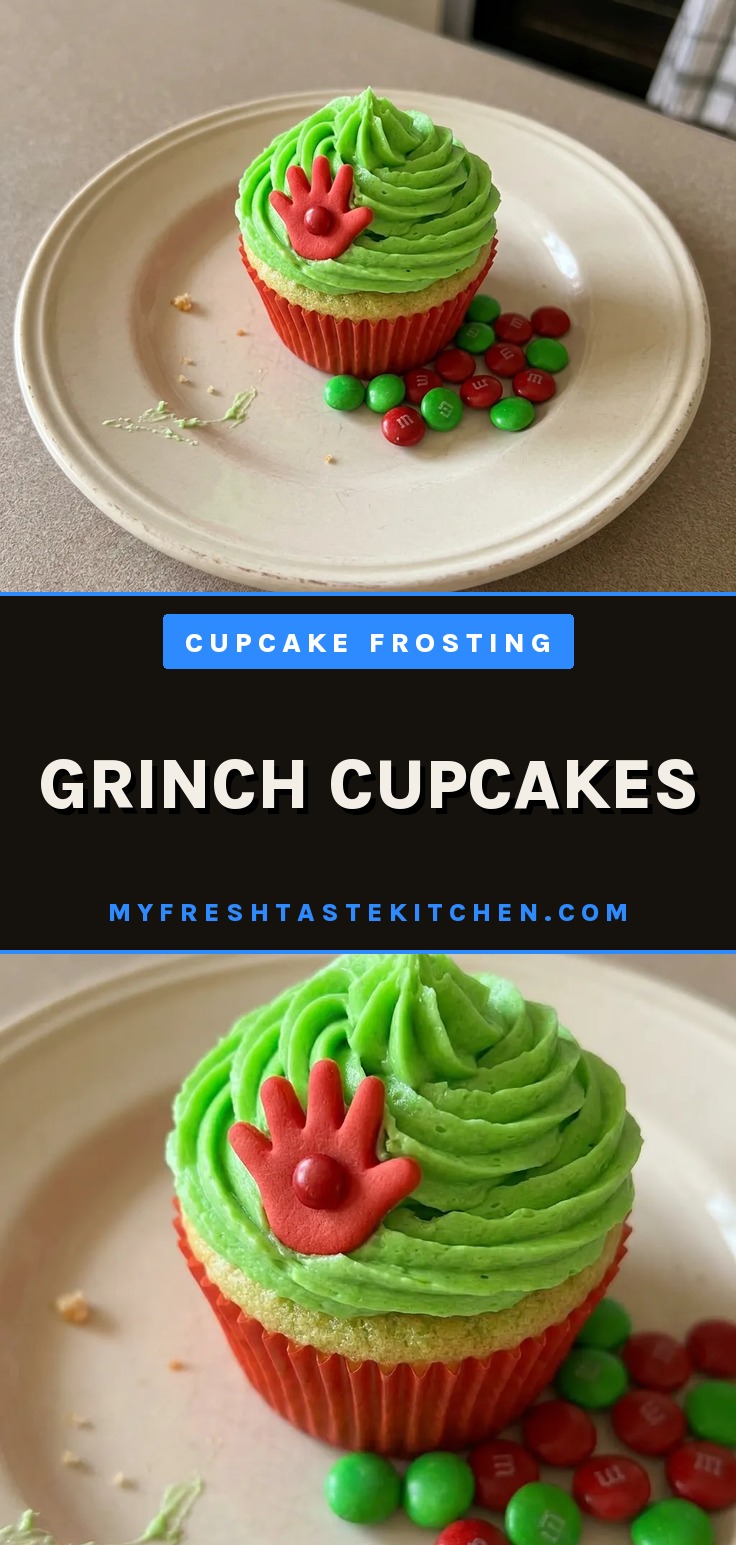 Overhead shot of three green cupcakes with white frosting, each topped with a red M&M.