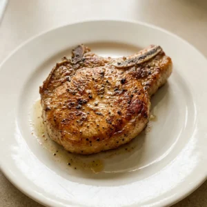 Overhead shot of two pork chops seasoned with brown sugar, smoked paprika, garlic and onion powders, and thyme.