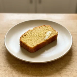 Looking down at a round golden loaf topped with sesame seeds and a pat of butter.