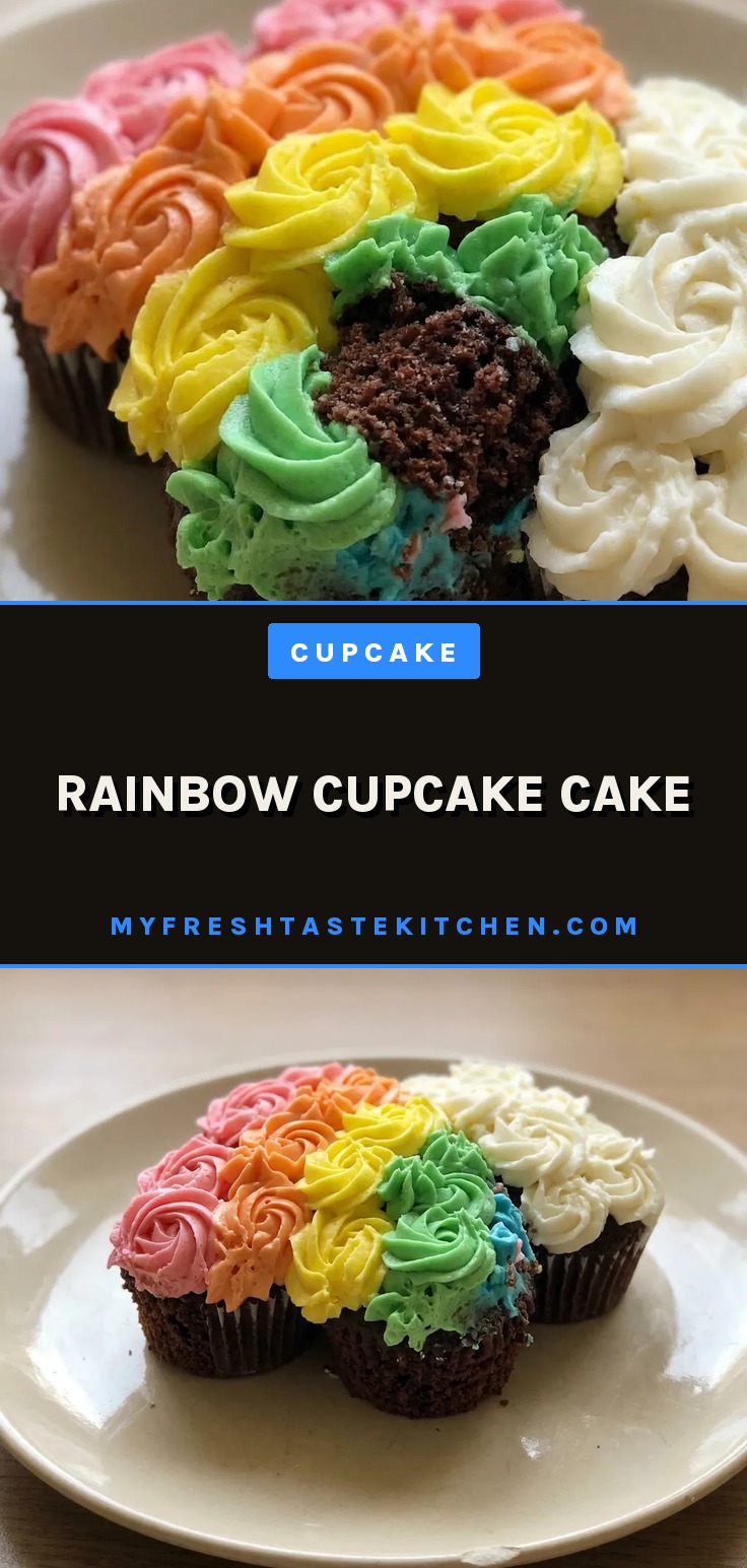 Looking down at a rainbow cupcake cake with concentric rings of pink, yellow, green, and blue frosting, each topped with a white swirl.