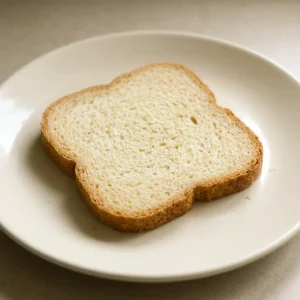Top-down look at a round loaf with golden crust and diagonal score marks.