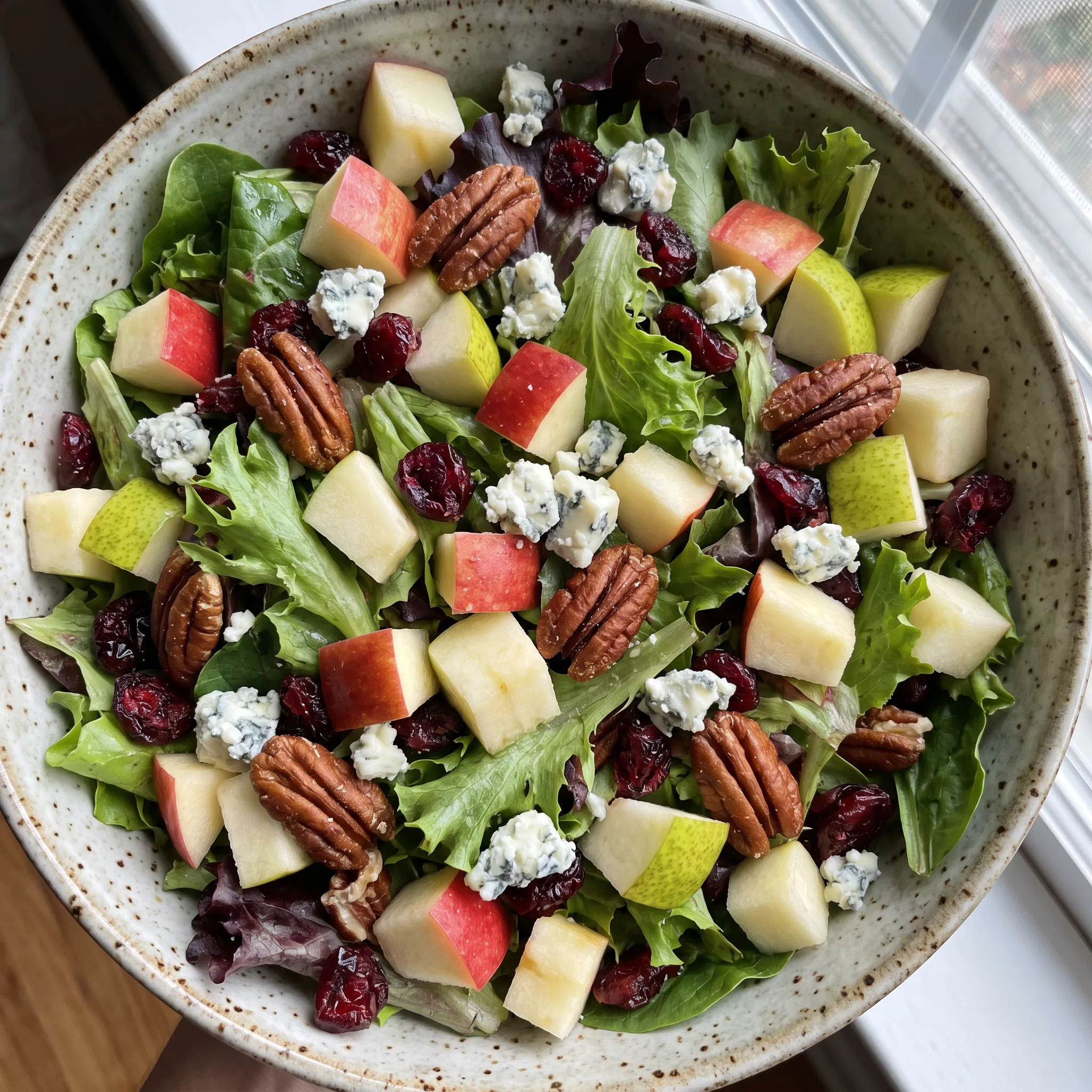 Apple Pecan Fall Salad with mixed greens, apple and pear slices, dried cranberries, blue cheese crumbles, and salted pecans.