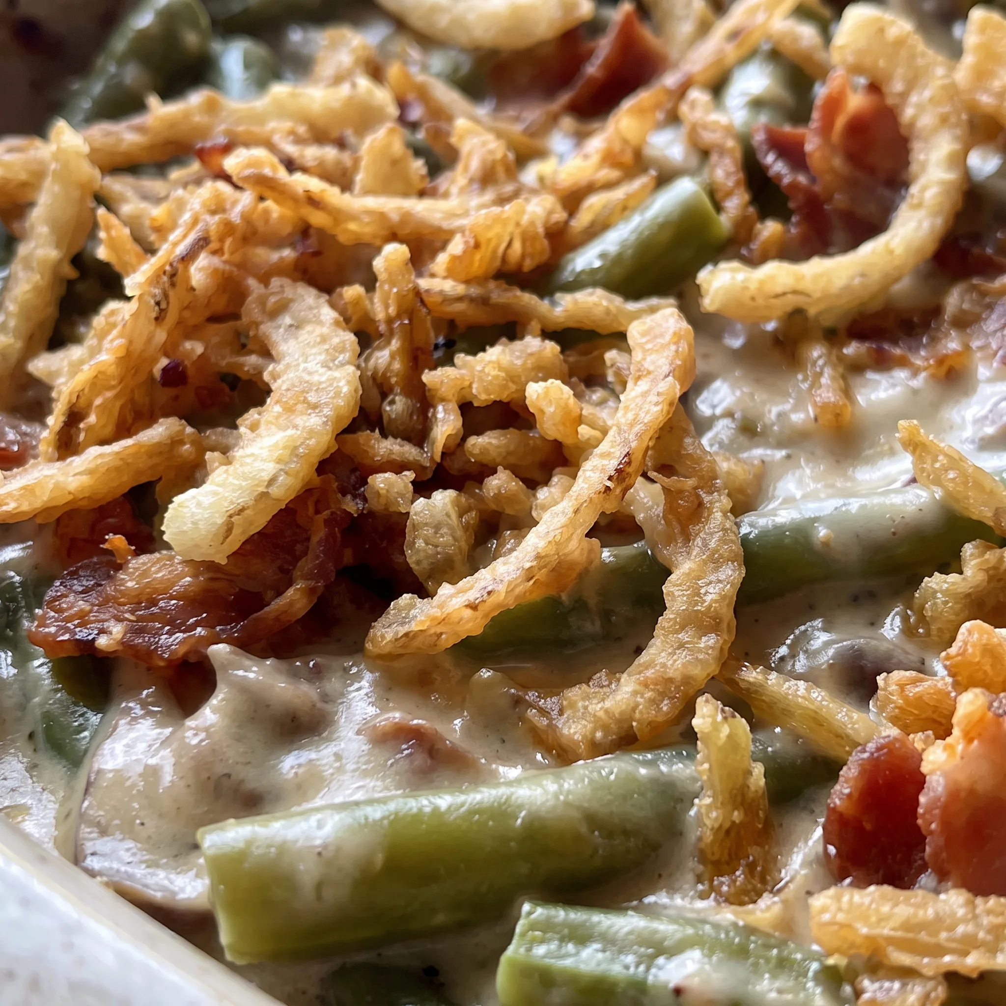 Crispy fried onions atop creamy cheese sauce with green beans and bacon bits.