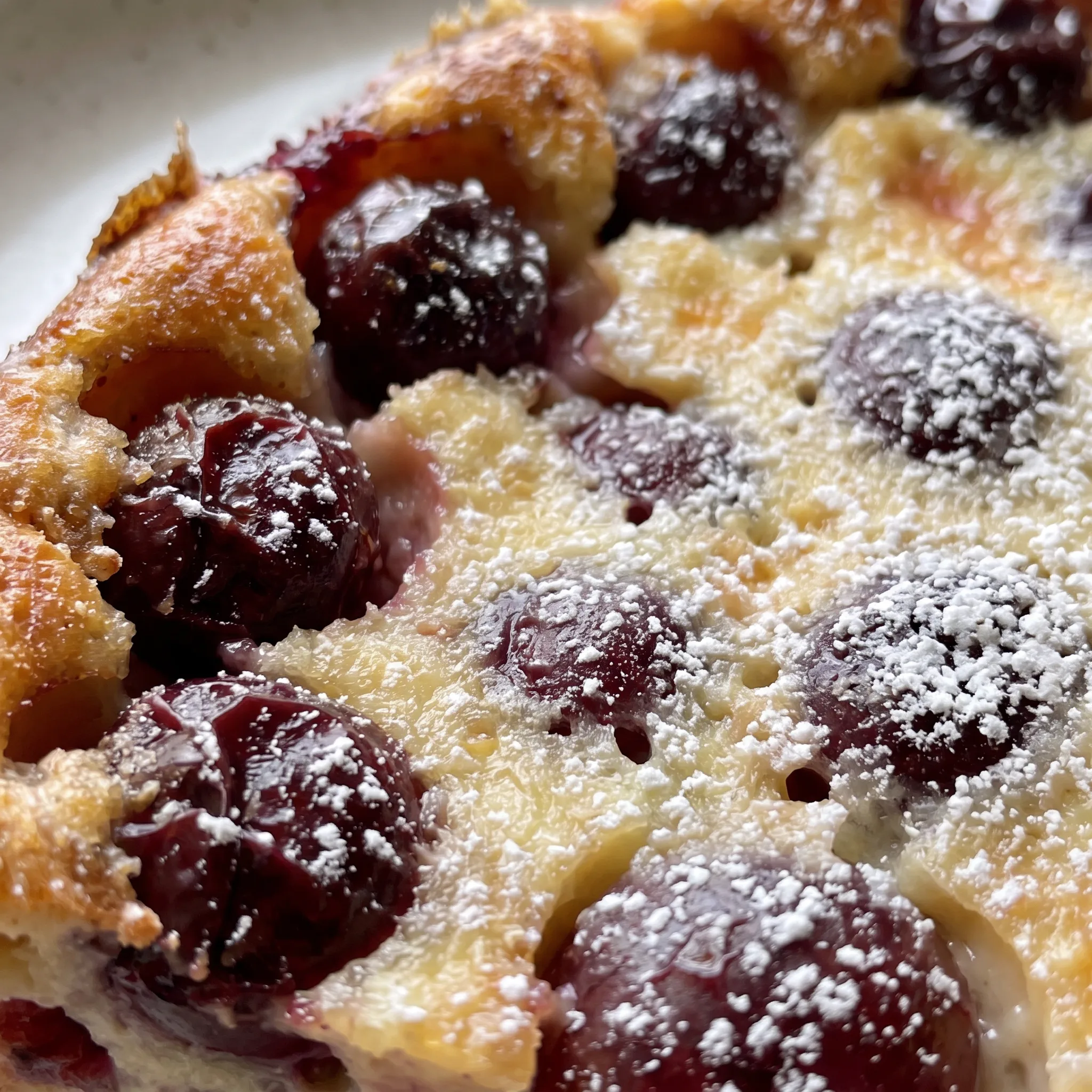 Smooth, creamy custard with a glossy surface, studded with plump, juicy cherries, and a hint of almond essence.