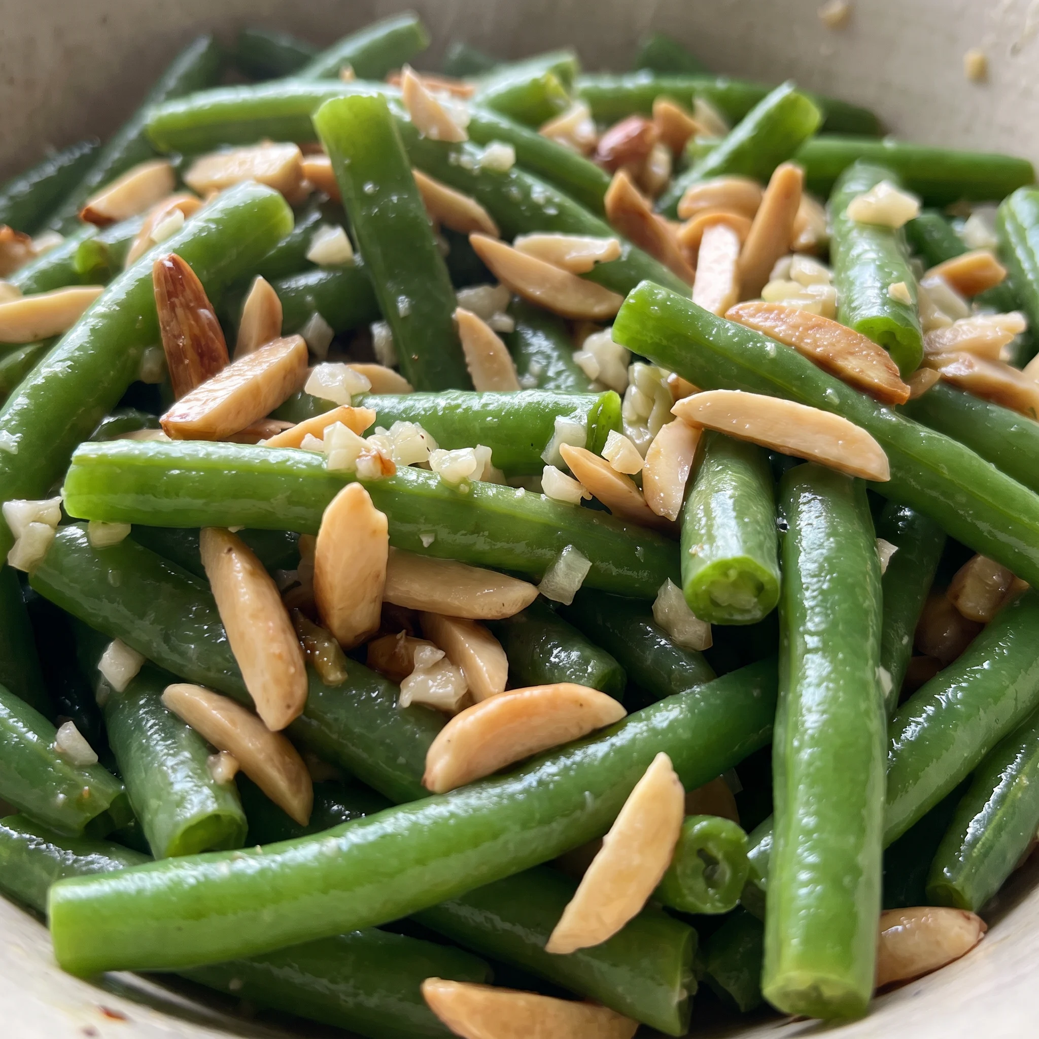 Glossy green beans coated in butter, topped with crunchy almond slices and bits of garlic.
