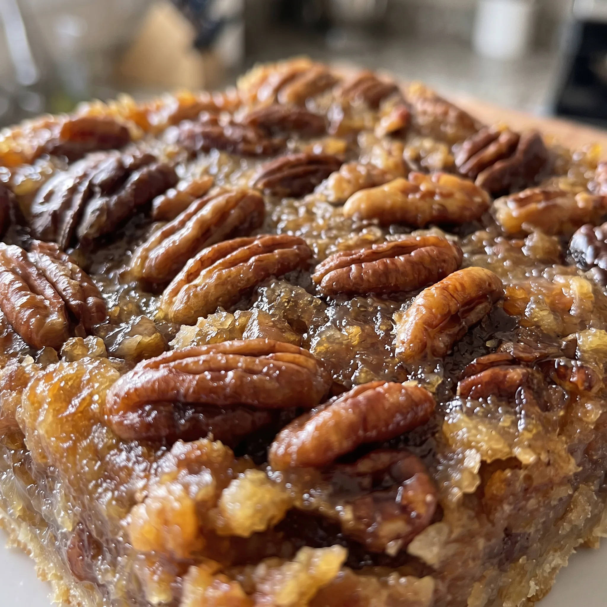Pecan pie bar with a sticky, caramelized corn syrup filling and crunchy pecan pieces.