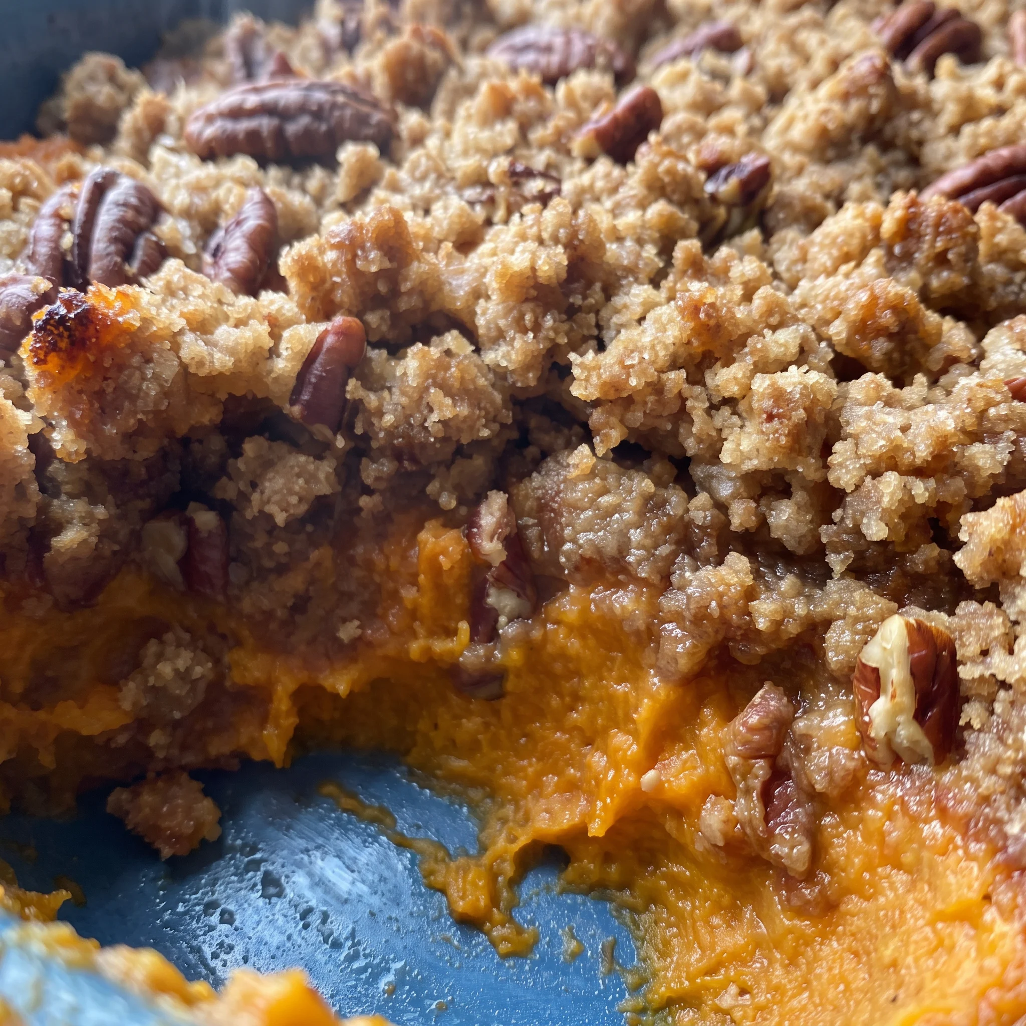 Glossy pecans clustered on a caramelized brown sugar and butter crust over smooth, orange sweet potato puree.