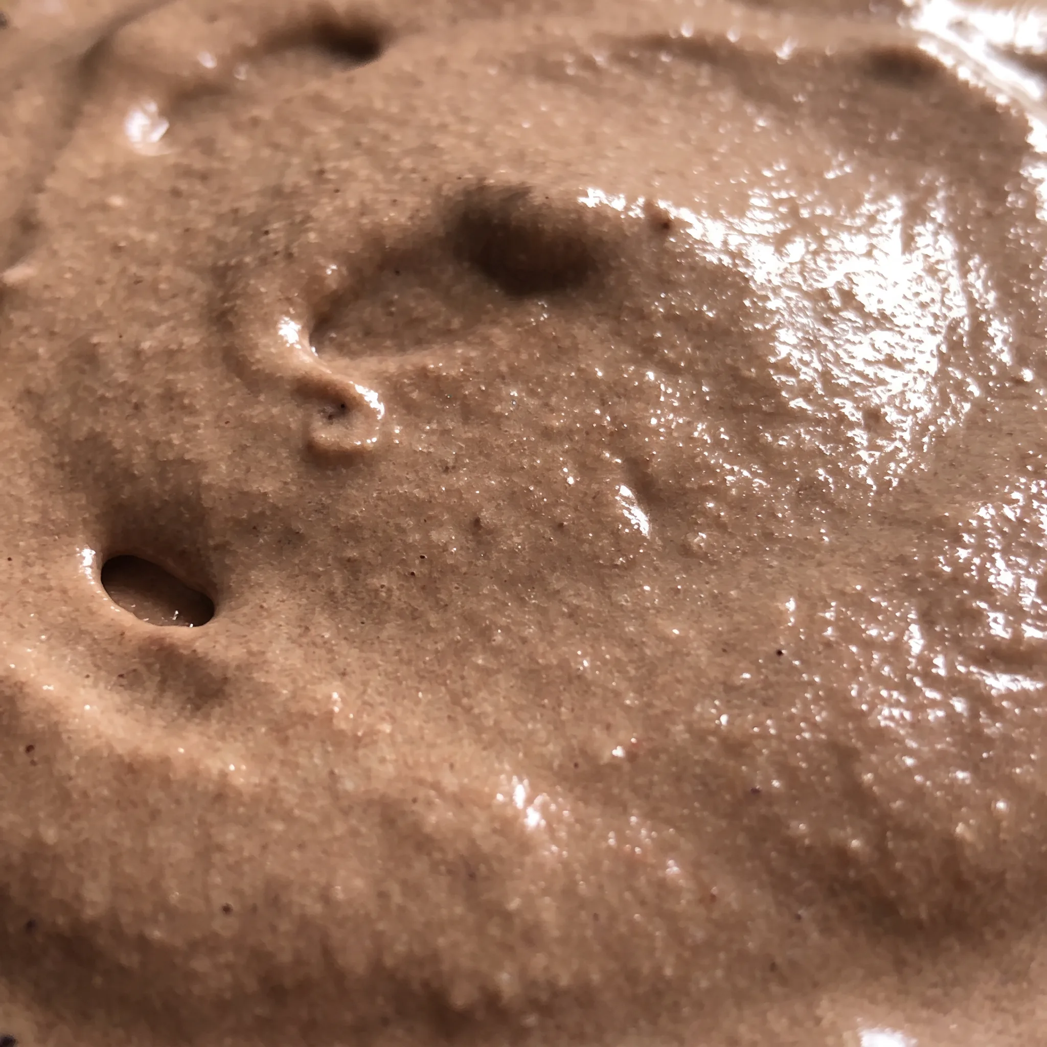 Smooth, dense chocolate frosty with a soft, creamy texture, its surface swirled with fluffy white Cool Whip.