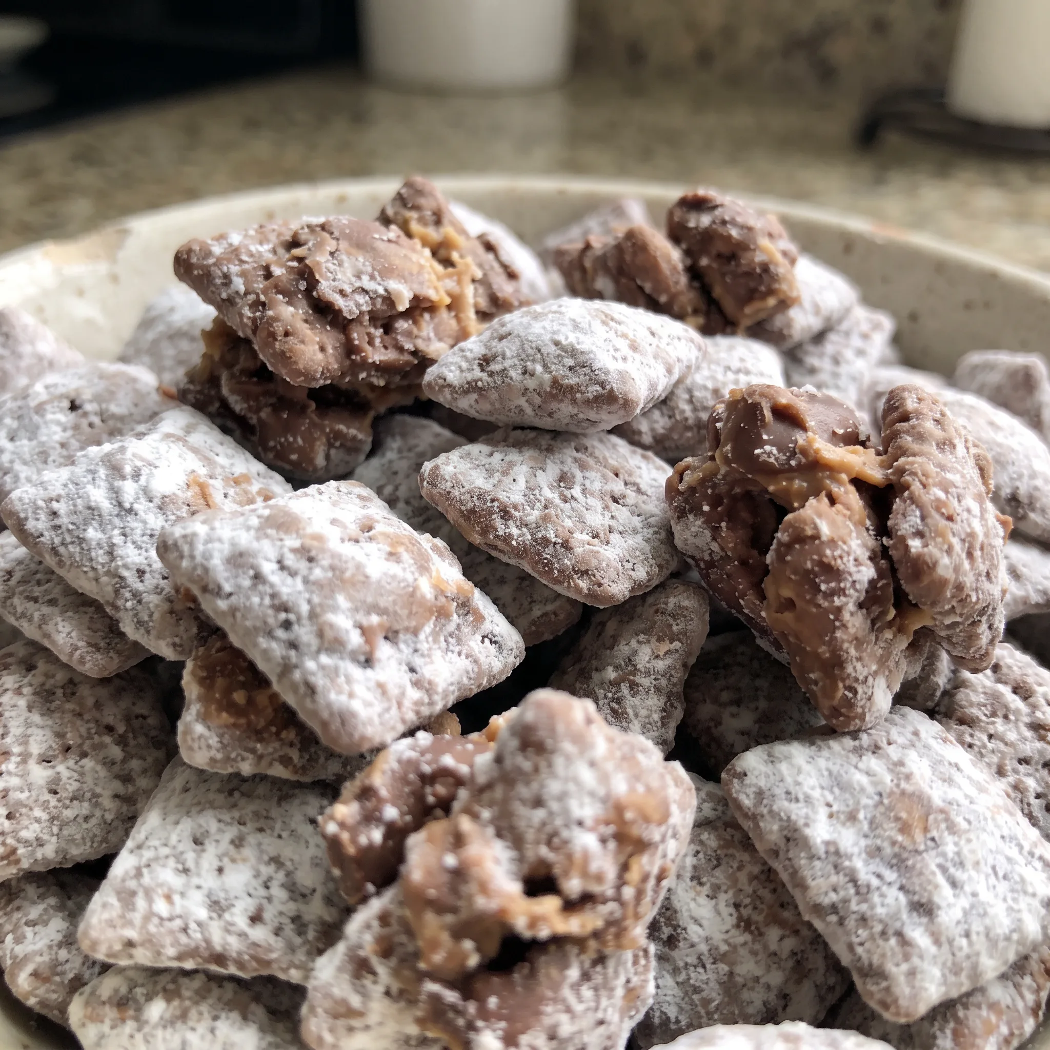 Powdered sugar coating on chocolate peanut butter covered cereal squares.